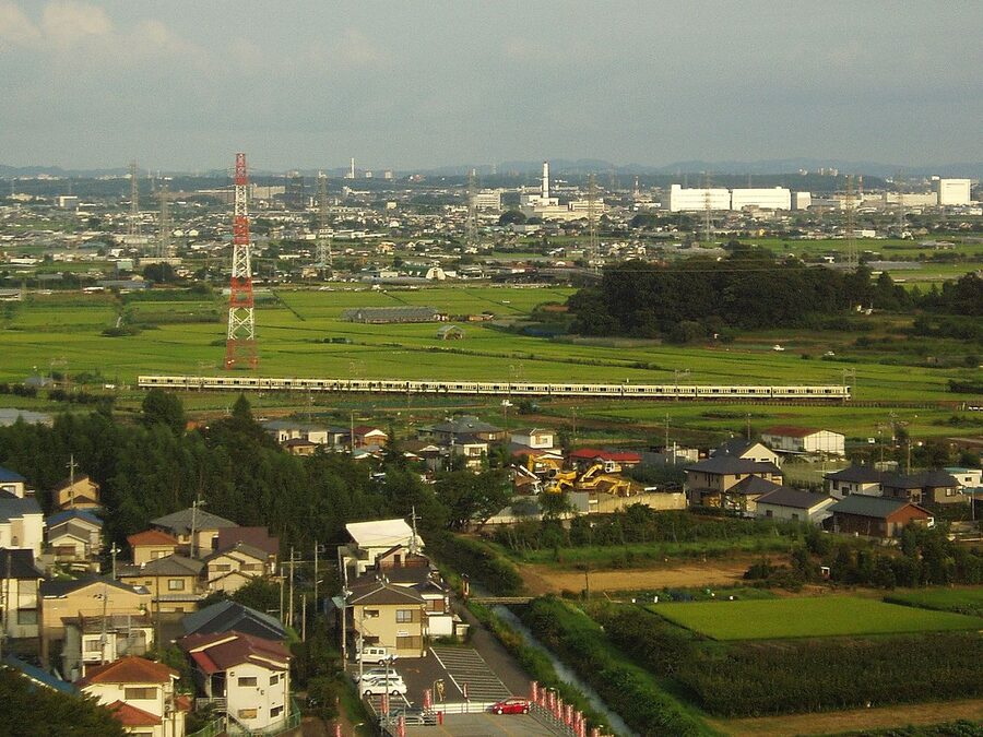 Odakyu Odawara Line train near Isehara Station with farmland beyond