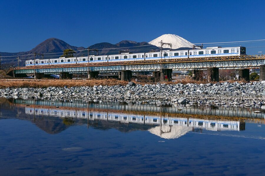 Odakyu local train crossing the Sakawa River bridge with Mt. Fuji behind