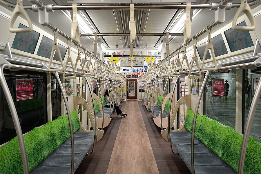 Interior of a Tokyu 2020 series train, with full-width LCD displays and longitudinal seating