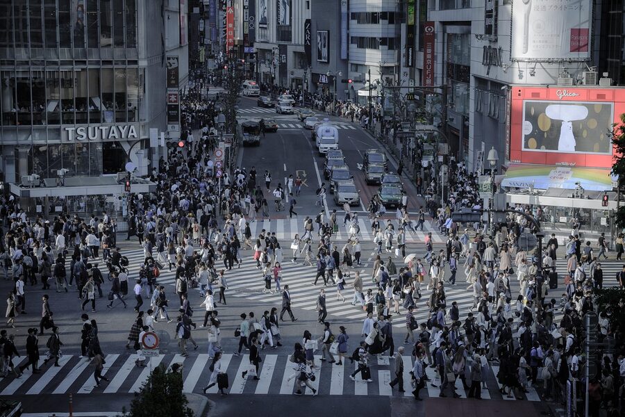 Shibuya Crossing intersection with cityscape, signboards and pedestrians