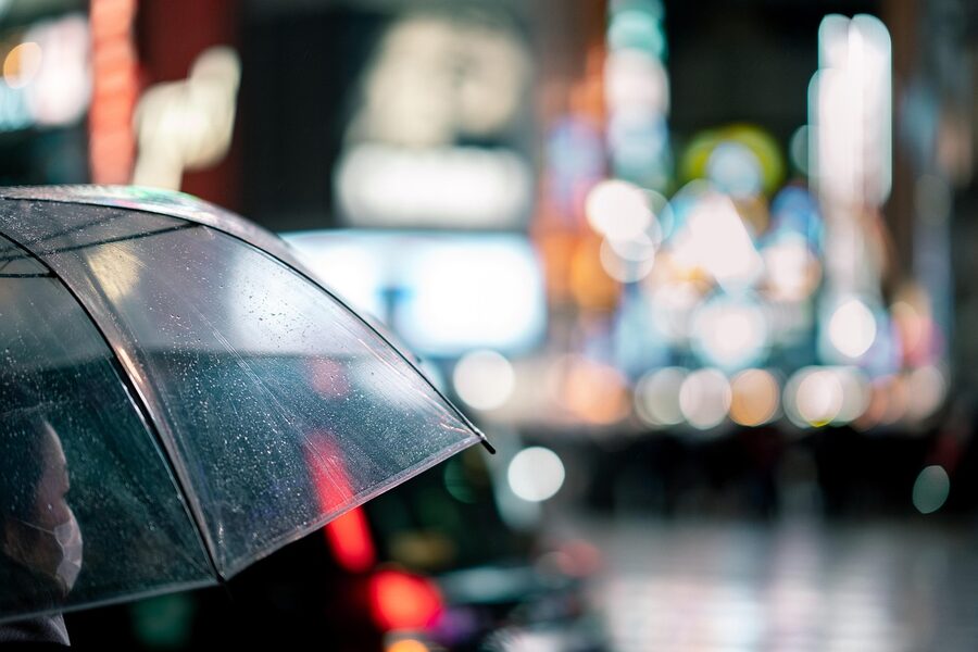 Shibuya Crossing at night with umbrella crowd