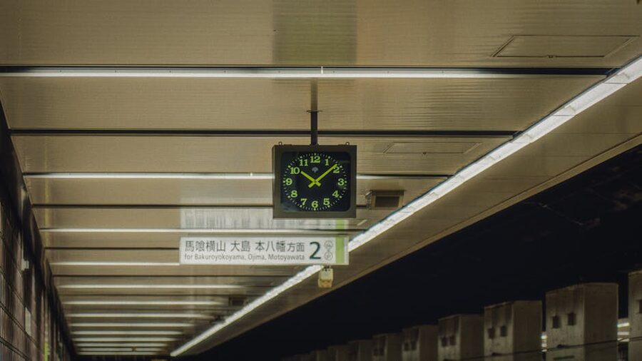 Tokyo subway platform with clock and signage